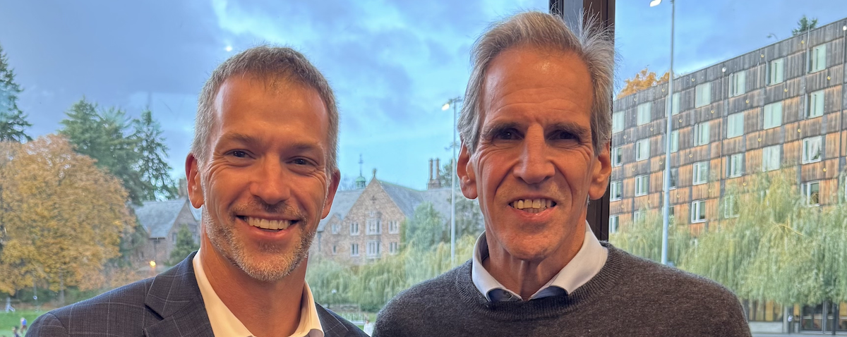 Two people in front of a window